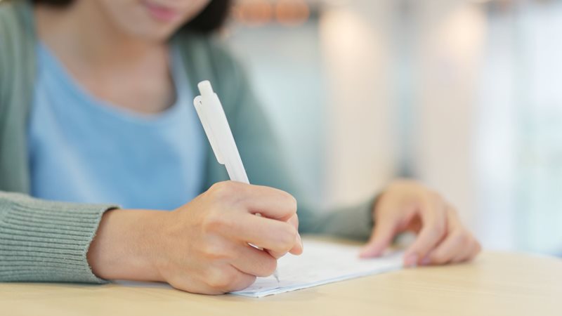 a close up of a woman's hand writing