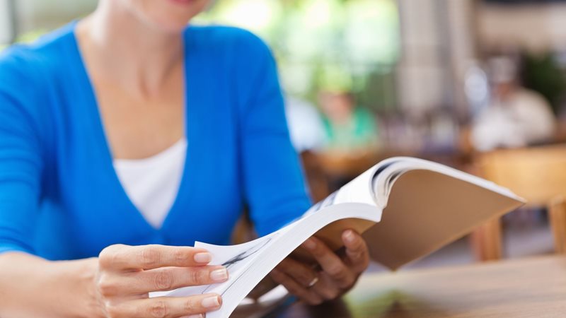 A woman in blue is reading a book