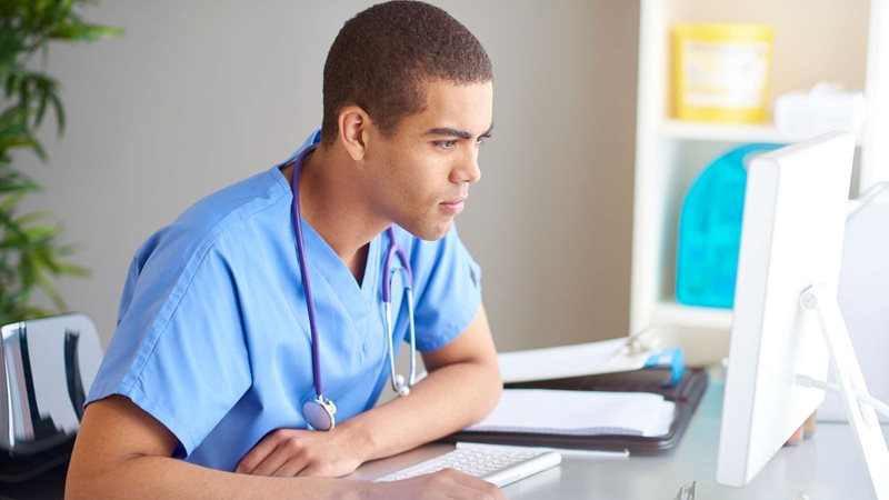 a medical student is starting at his computer screen